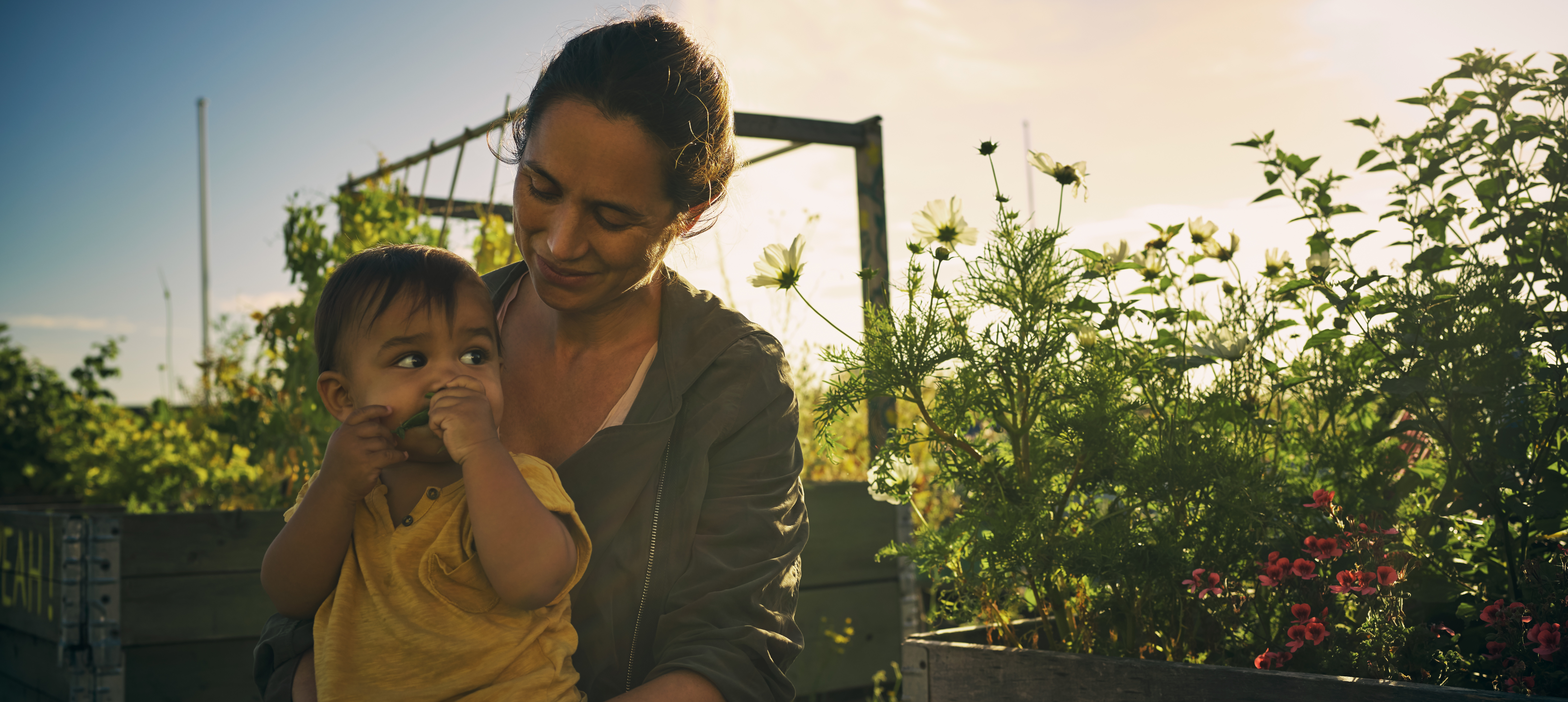 A woman and a child sit together in a field.