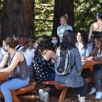 Picture of students sitting on picnic tables for the College Scholars Program kick-off event.