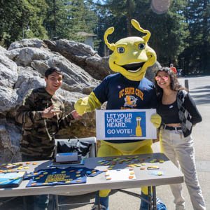 Tabling voting campaign with two students and Sammy the Slug 