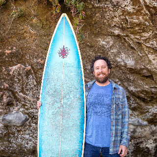 David Schulkin Holding Surfboard
