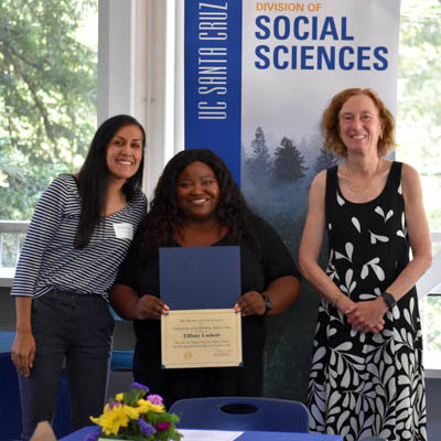 Tiffany Lockett (center) receives the Milam-McGinty-Kaun Award for Teaching Excellence, awarded by Associate Professor of Psychology Rebecca Covarrubias (left) and Social Sciences Dean Katharyne Mitchell (right).